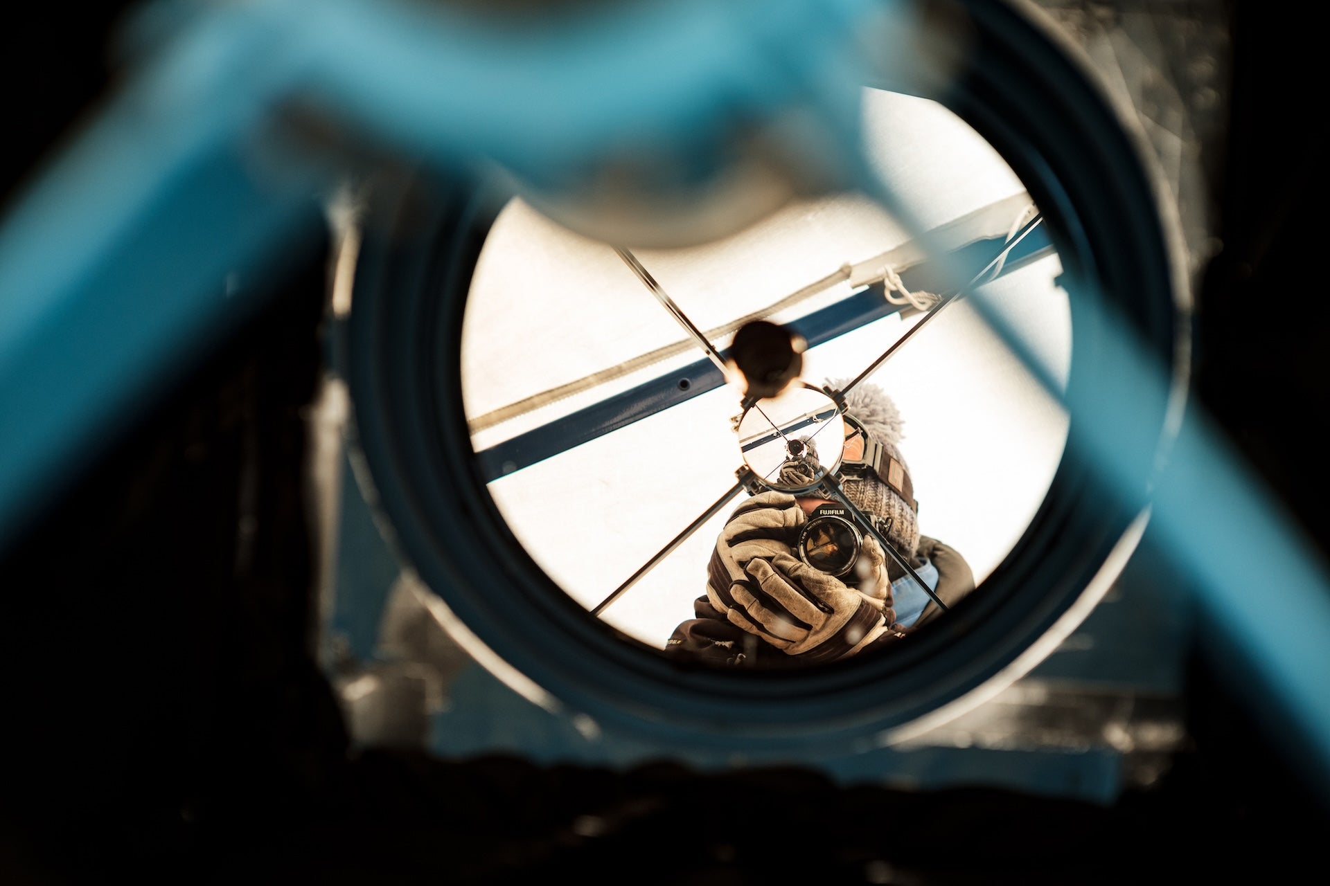 moi en train de me photographier dans les reflets d'un très gros télescope sur la station antarctique Concordia 